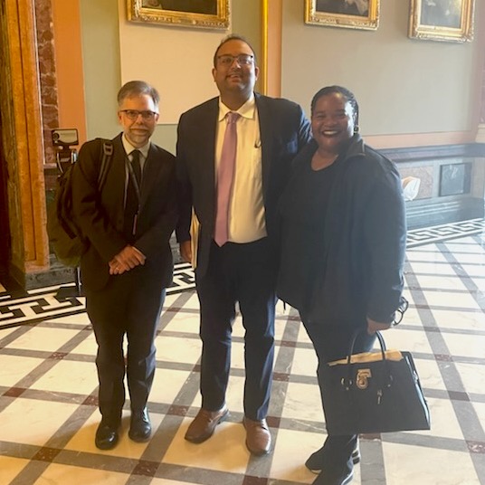 Photo of three people at state capitol building